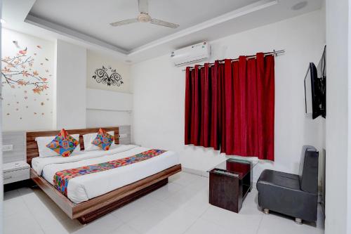 a bedroom with a bed and a red curtain at FabHotel Saanvi Paradise in Bhopal