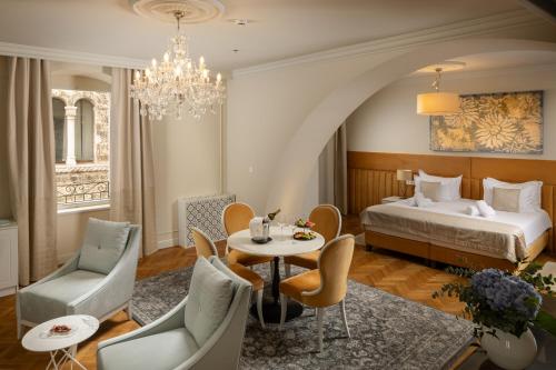 a hotel room with a bed and a table and chairs at Heritage hotel Santa Lucia in Split