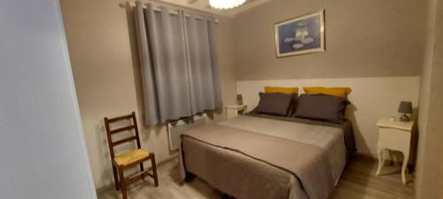 a bedroom with a large bed and a chair at Gite des Reguinelles in Saint-Lattier