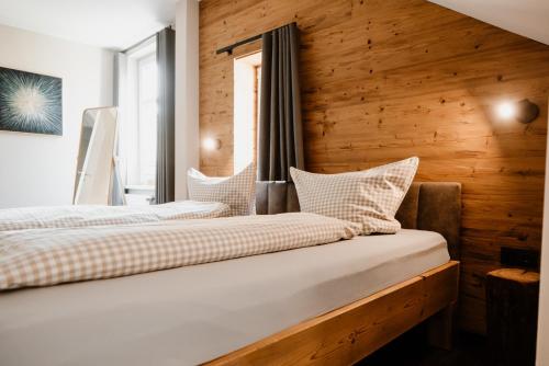 two beds in a room with a wooden wall at KleineAuszeit in Blankenburg