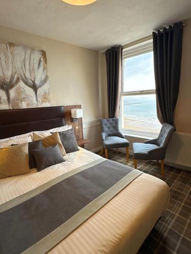 a bedroom with a large bed and a large window at The Selomar in Scarborough