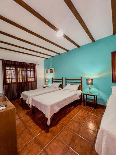 a bedroom with two beds and a blue wall at Hotel San Marco  in Santo Domingo