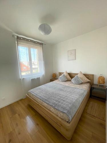 a bedroom with a large bed and a window at Appartement Fleur De Houblon in Schiltigheim