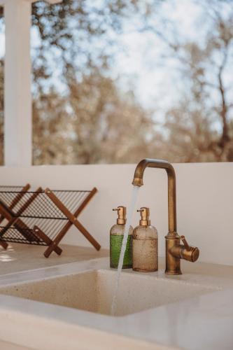 a kitchen sink with water pouring from a faucet at Trullo Serenità Charming Trullo with Private Pool in Apulië in Ceglie Messapica