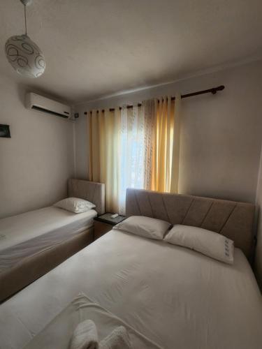 a bedroom with two beds and a window at Villa Kena in Ksamil