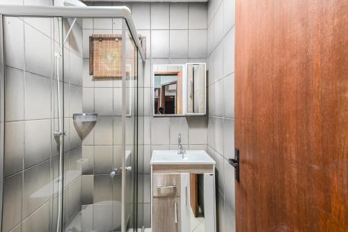 a bathroom with a sink and a shower at Hospedaria Nativa in Praia do Rosa