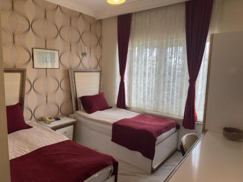 a bedroom with two beds and a window at Otel Nisa in Nevşehir