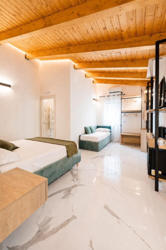 a bedroom with two beds and a couch at Casa Madrigale - radici e ritorni in Praia a Mare