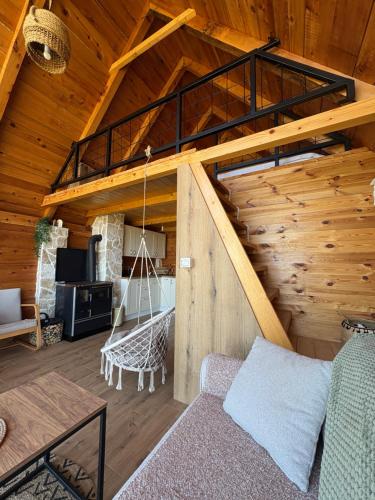 a living room with a loft with a swing at Javorje Eco Cabin in Kolašin