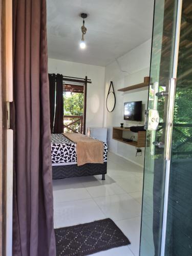 a bedroom with a bed and a sliding glass door at Pousada Encanto do Mutá in Barra Grande
