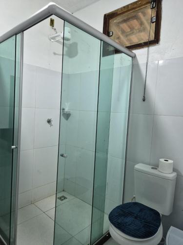a bathroom with a glass shower with a toilet at Pousada Encanto do Mutá in Barra Grande