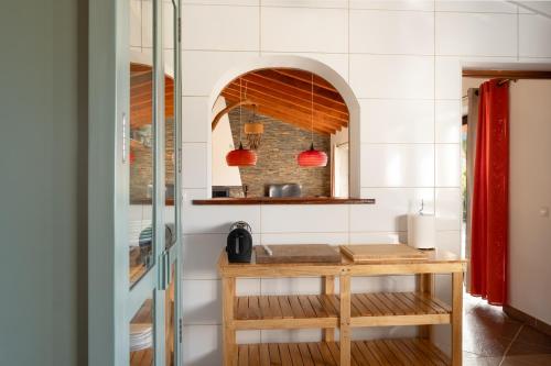 a kitchen with a wooden table in a room at Vida Pura Guesthouse in Odeceixe