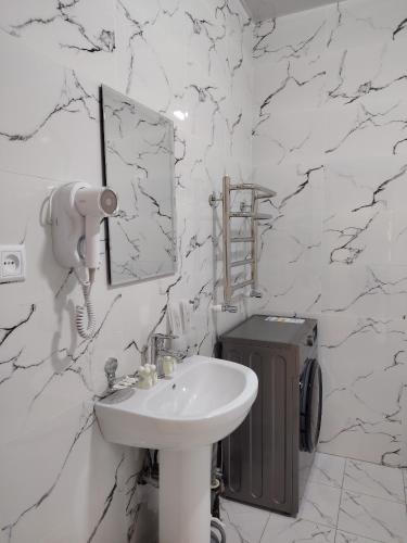 a white bathroom with a sink and a mirror at Парк апарт-отел in Namangan