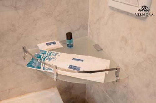 a glass table in a bathroom with towels on it at Velmora Luxe Residences in Madurai
