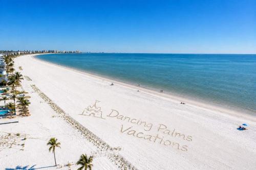 a beach with a sign that reads dancing palms vacations at Beach Bound - 2025 Luxury Build - Walk to Beach & Town in Fort Myers Beach