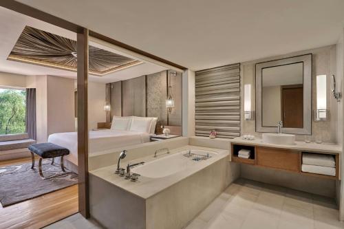 a bathroom with a bed and a tub and a sink at ITC Mughal, A Luxury Collection Resort & Spa, Agra in Agra