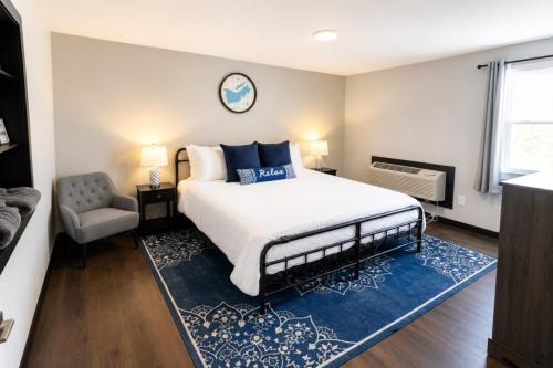 a bedroom with a large bed and a chair at Private King Studio Close To The Action in Muskegon