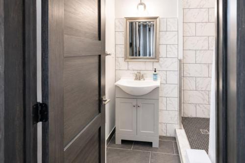 a bathroom with a sink and a mirror and a door at Private King Studio Close To The Action in Muskegon