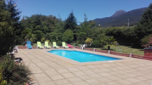 a swimming pool with lawn chairs at Puelche de Antuco in Antuco