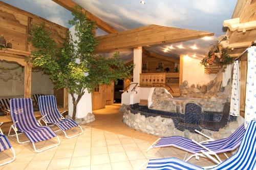 a patio with chairs and a stone fireplace at Das Grünholz Aparthotel in Mühlbach am Hochkönig