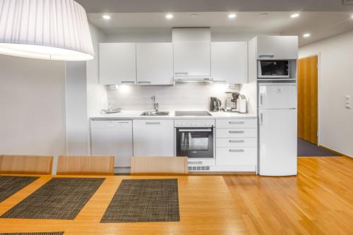 a kitchen with white appliances and wooden floors at Ruka Ski Chalets in Ruka