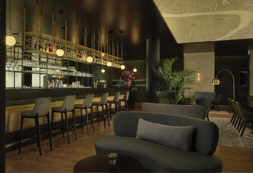 a bar with a row of chairs and a bar counter at Park Plaza Amsterdam Airport in Lijnden
