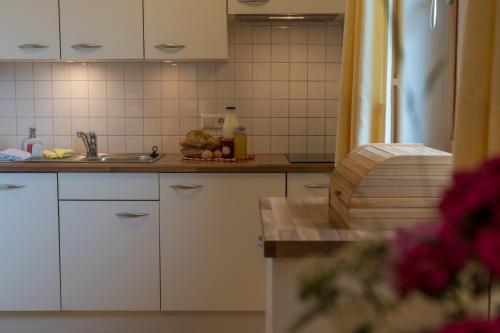 a kitchen with white cabinets and a sink at Ferienhof Blaas in Malles Venosta