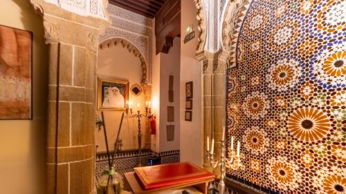 a bathroom with a shower and a tile wall at Dar Lalzohra in Rabat