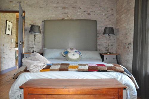a bedroom with a large bed and two lamps at Schuilhoek Cottage - Your perfect hide away! in Calitzdorp