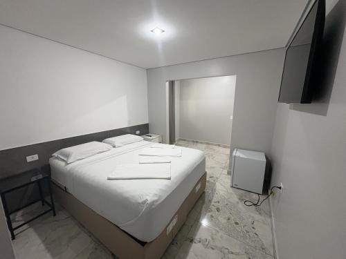 a bedroom with a bed and a flat screen tv at Hotel Paddock in São Paulo