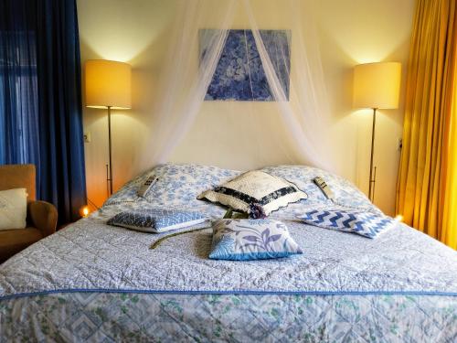 a bed with blue and white pillows on it at De Rozenhof in Groningen