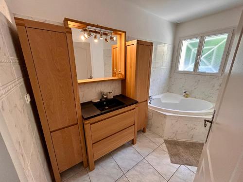 a bathroom with a sink and a bath tub at Villa à Pyla-sur-Mer avec piscine in La Teste-de-Buch
