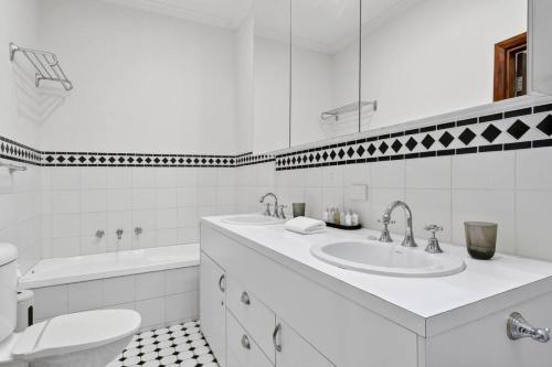 a white bathroom with a sink and a toilet at Marram House - Views in Marengo in Marengo