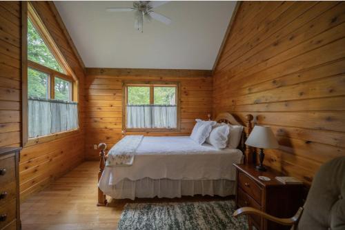 a bedroom with a bed in a wooden cabin at Agape Aldea in Jamestown