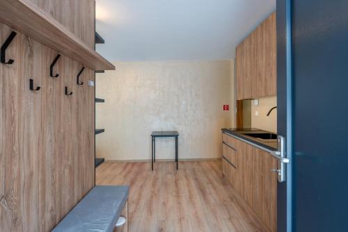 a kitchen with wooden cabinets and a table at Mama Boutique Apartment in Krušetnica
