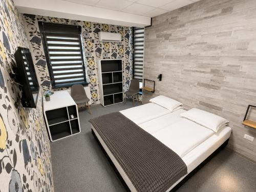 a bedroom with a bed in a room with a stone wall at Zen Rooms in Suceava