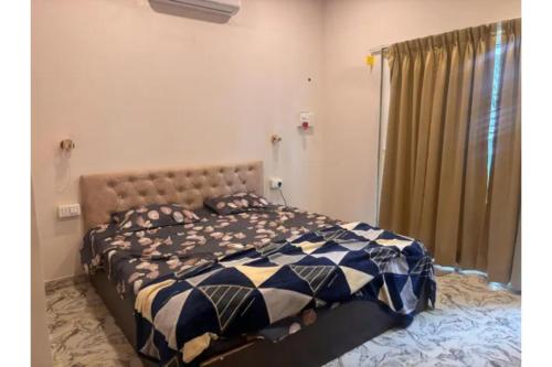 a bedroom with a bed with a blue at FabHotel Hill View Cottages in Arpora