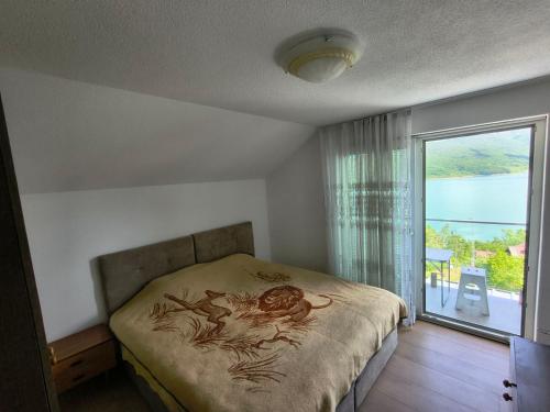 a bedroom with a bed and a large window at Villa Nena in Mavrovi Anovi