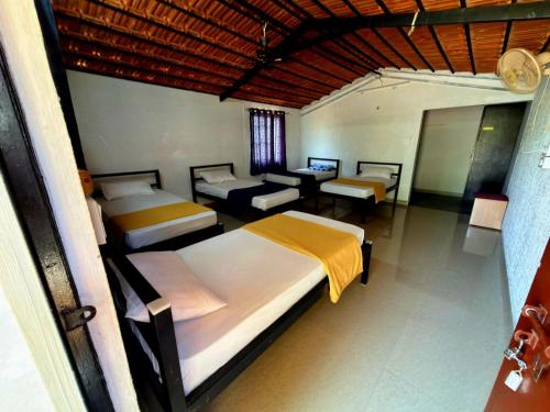 a bedroom with two beds and a table and chairs at Valley Vibes in Rāmanagaram