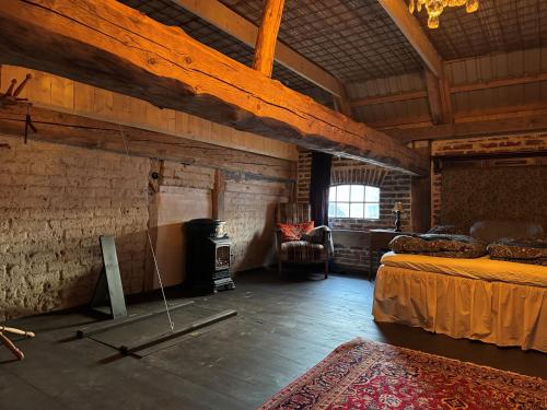 a room with a bed and a stove in it at Anno 1782 Unique Romantic Glamping at the Manors Historic Barn in Arnager