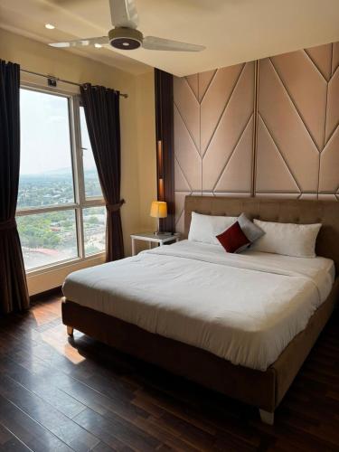 a bedroom with a large bed and a large window at Elysium Tower Luxury Apartments Islamabad Opposite Centaurus Mall in Islamabad