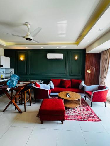 a living room with a red couch and a table at Elysium Tower Luxury Apartments Islamabad Opposite Centaurus Mall in Islamabad