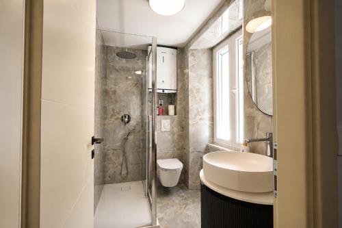 a bathroom with a shower and a toilet and a sink at Villa Mater in Trogir