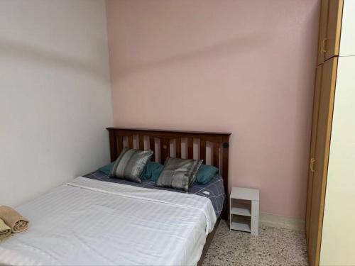 a bedroom with a bed with two pillows on it at 8minit walk to jongke in Malacca