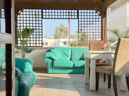 a living room with a green couch and a table at Only Teens - Baia Verde in Baia Verde