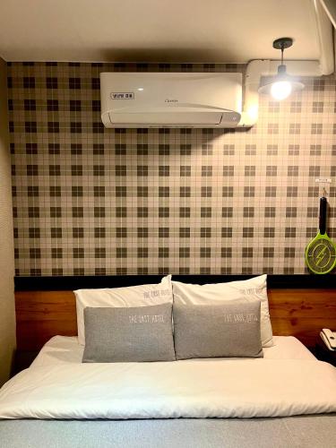 ein Bett mit zwei Kissen darauf in der Unterkunft The Last Hotel Nampo in Busan