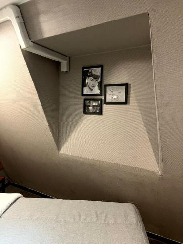 ein Zimmer mit zwei Bildern an der Wand und einem Bett in der Unterkunft The Last Hotel Nampo in Busan