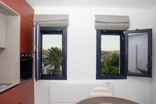 a kitchen with two windows and a table in a room at Aellia Bay Residences in Alinda