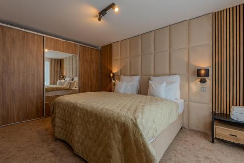 a hotel room with a large bed and a mirror at Mama Boutique Apartment in Krušetnica