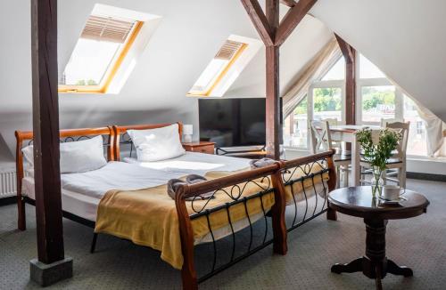 a bedroom with two beds and a table and windows at Villa Rafa in Mielno